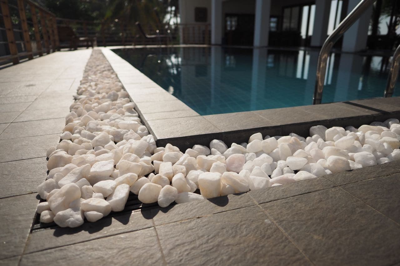 Seascape infinity pool edge with white pebbles